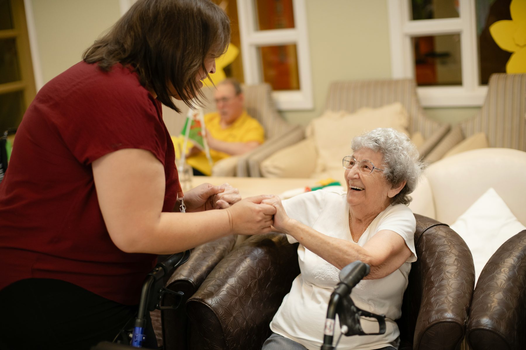 Residents and a caregiver together in a community lounge