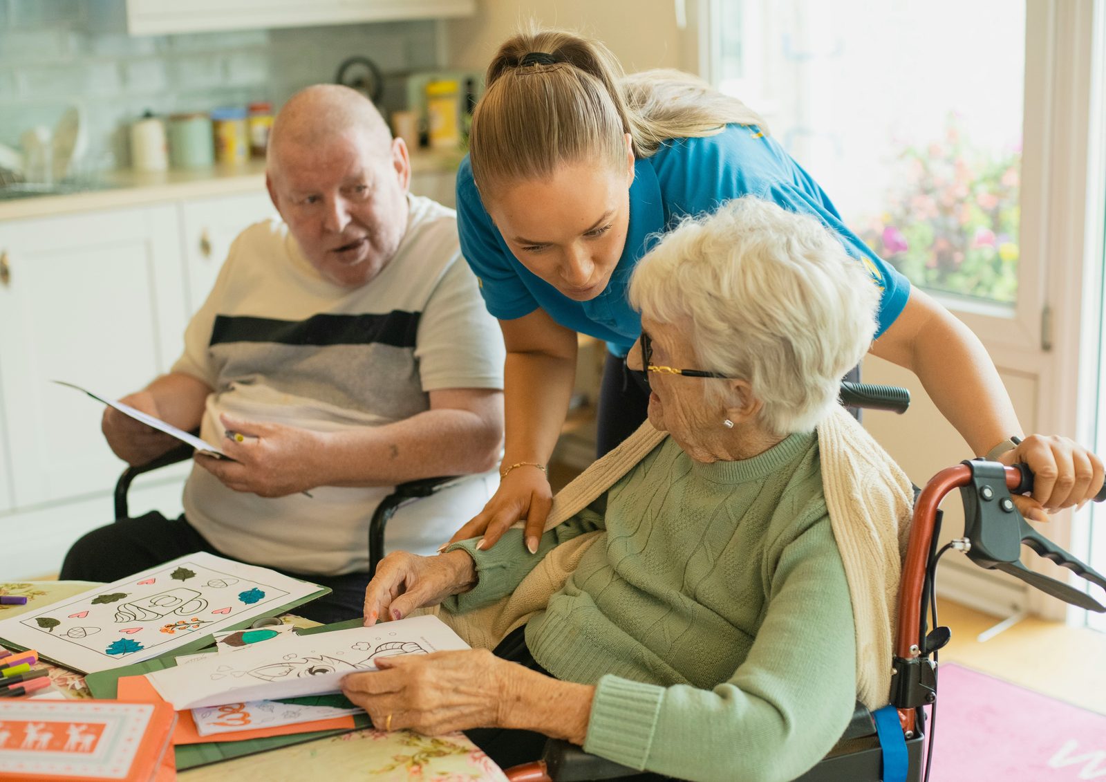 A caregiver sitting with a client at a kitchen table
